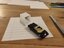 Photo of a toy driving into a drawn garage that looks three-dimensional by optical illusion.