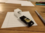 Photo of a toy driving into a drawn garage that looks three-dimensional by optical illusion.